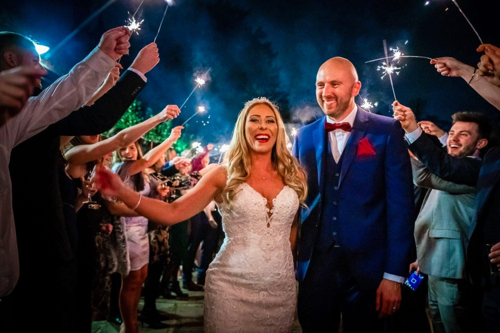 Wedding couple walking through sparklers at their Great Fosters wedding