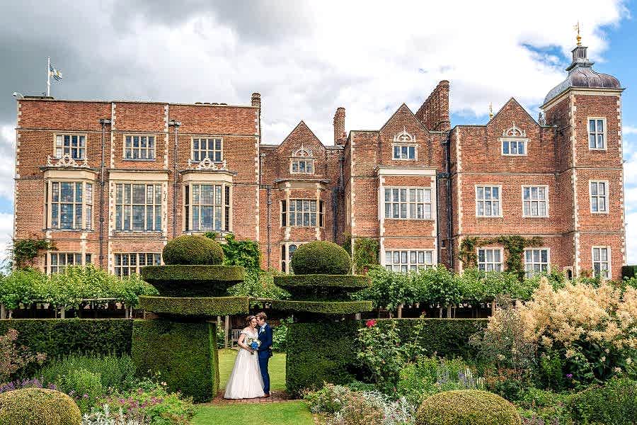 Hatfield House Wedding photo. Portrait of couple in the gardens, with Hatfield House in the background