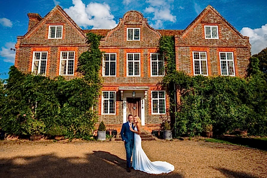 Littlefield Manor Wedding Photography - Portrait of wedding couple standing in front of the Jacobean House at Littlefield Manor near Guildford, Surrey